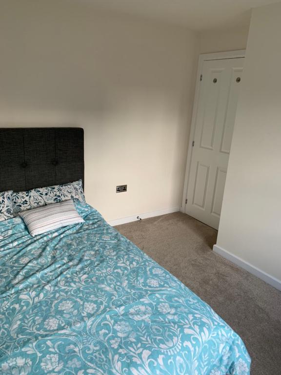 - une chambre avec un lit et une couette bleue dans l'établissement 3 Lace Avenue LE11 2FE, à Loughborough