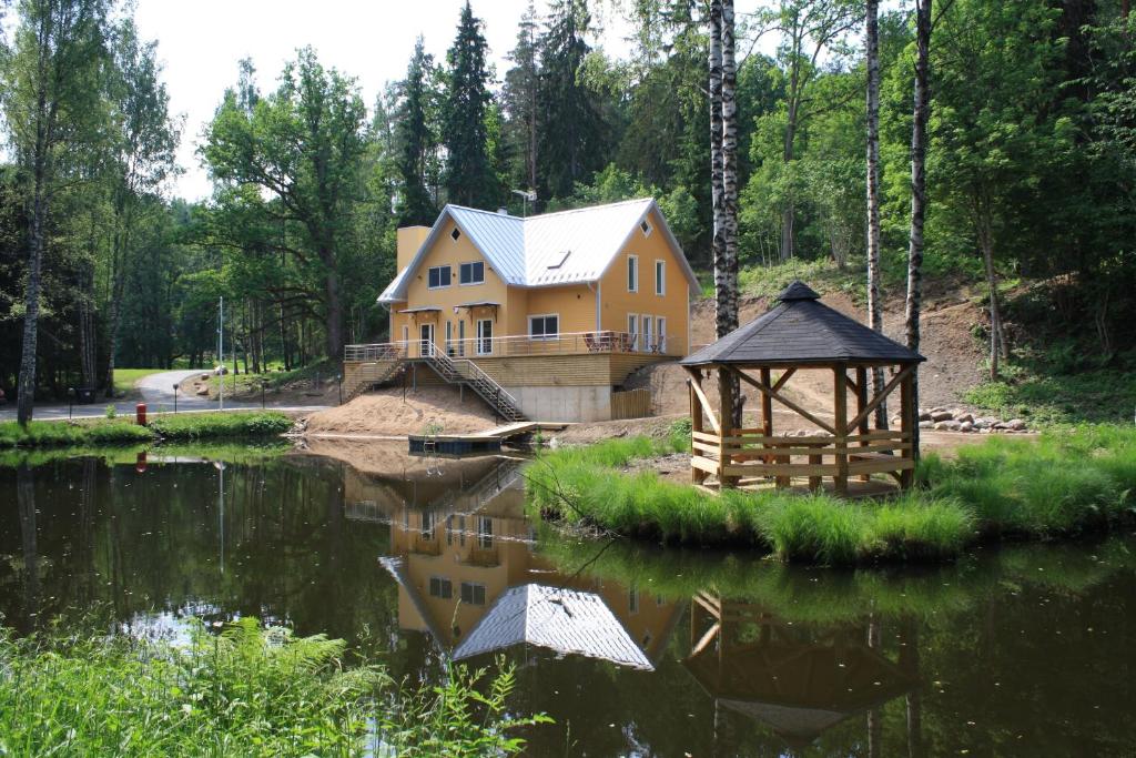 a house in the woods next to a lake at Tehvandi Puhkemaja in Otepää