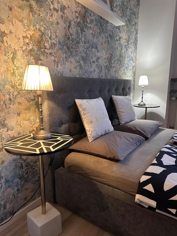 een slaapkamer met een bed en een tafel met een lamp bij Nice Stay Apartment Centrum in Warschau