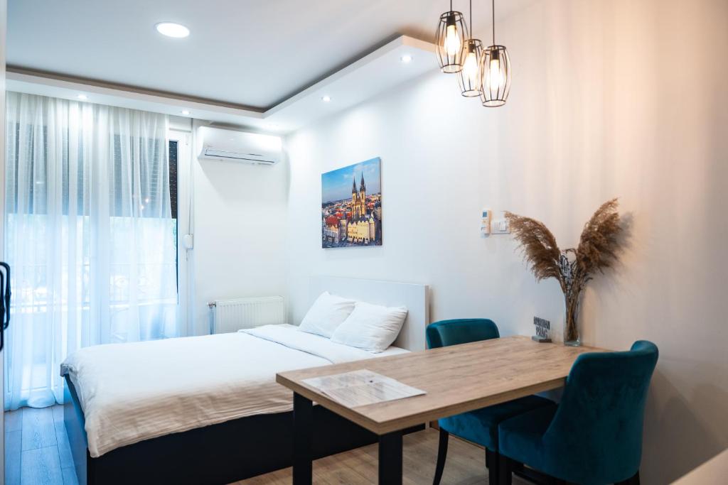 1 dormitorio con 1 cama, mesa y sillas en Daisy resort en Novi Sad