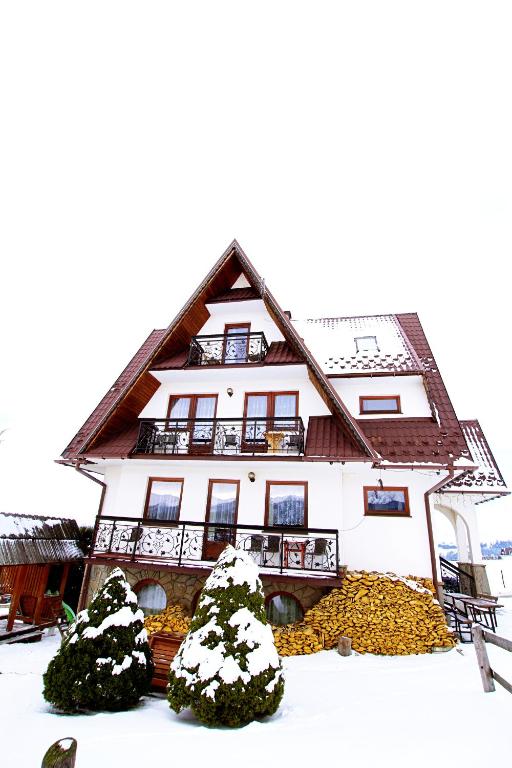 a house with snow on the ground in front of it at DOM BUDZOWA 2B in Murzasichle