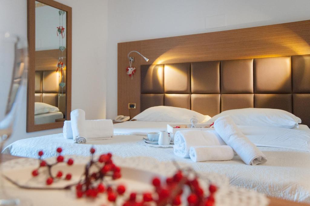 een slaapkamer met 2 bedden, handdoeken en een spiegel bij Hotel Caserta Antica in Caserta
