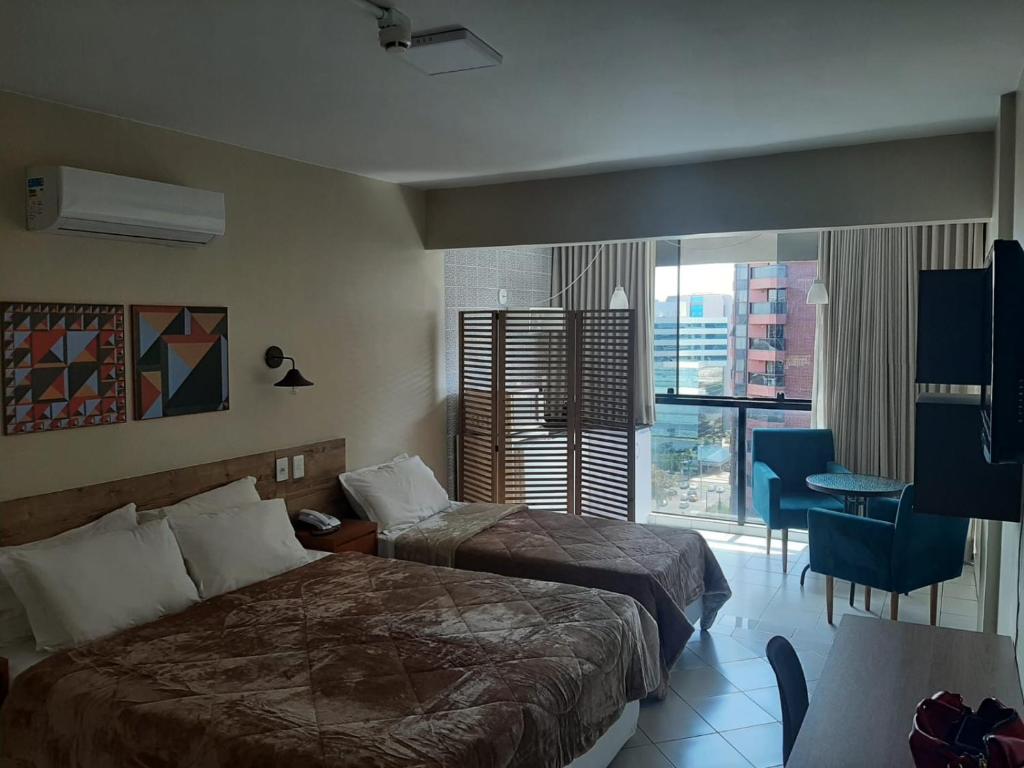 GARVEY PARK HOTEL في برازيليا: غرفة فندقية بسريرين ونافذة