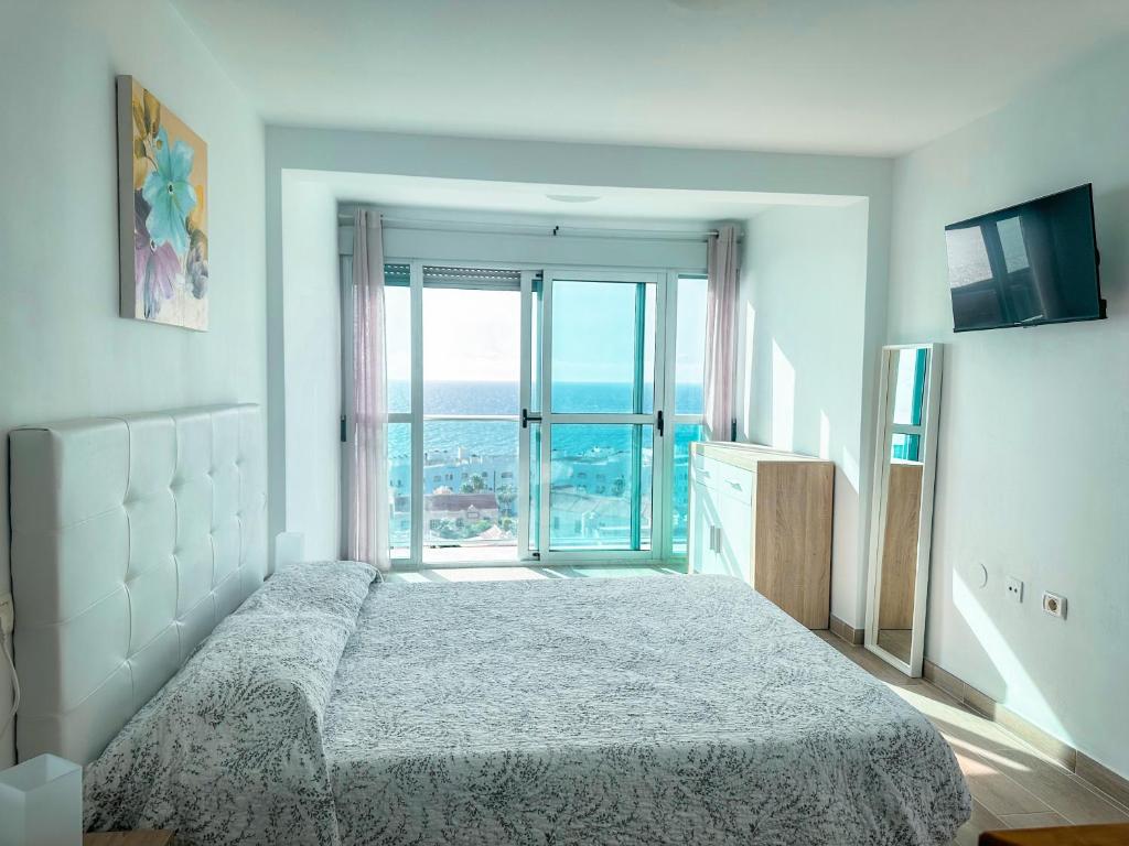 a bedroom with a bed and a large window at Attico 512 - Golf del Sur in San Miguel de Abona