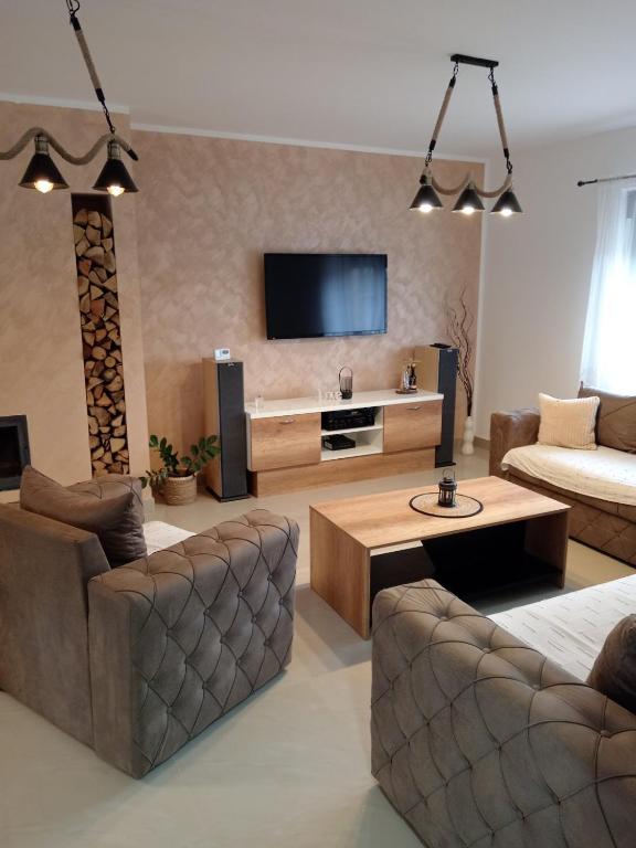 ein Wohnzimmer mit einem Sofa und einem TV in der Unterkunft Apartman SARA in Vršac