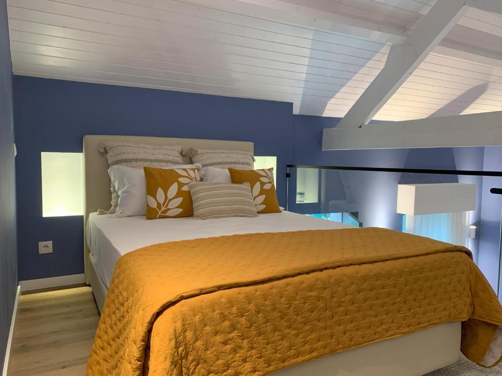 a bedroom with a large bed with blue walls at MyTrip Porto in Matosinhos