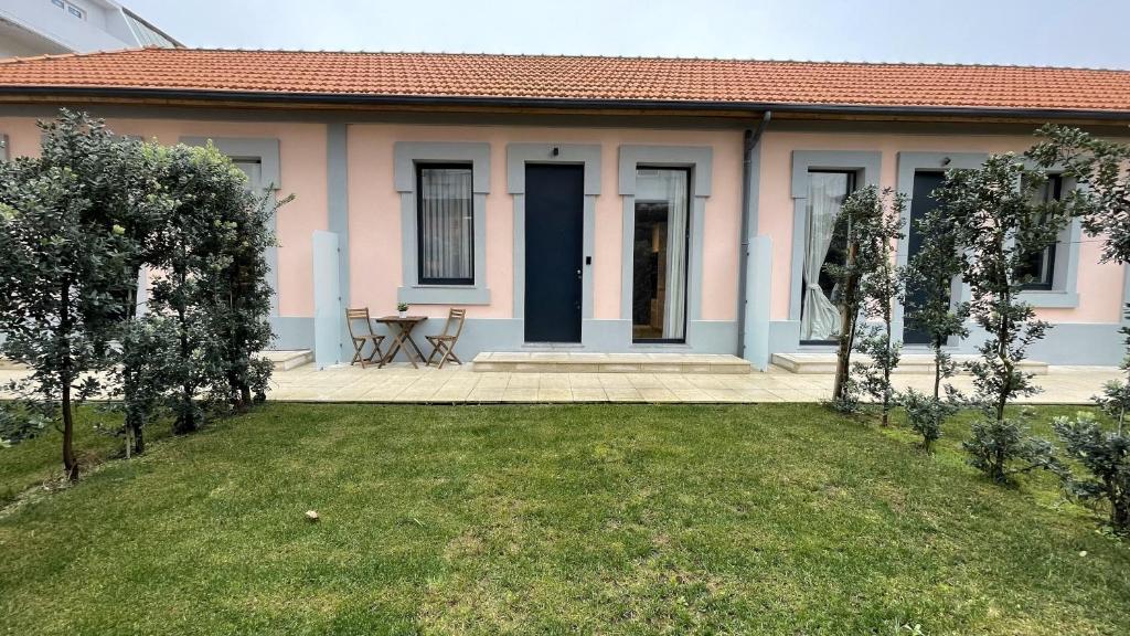 a pink house with a lawn in front of it at MyTrip Porto in Matosinhos