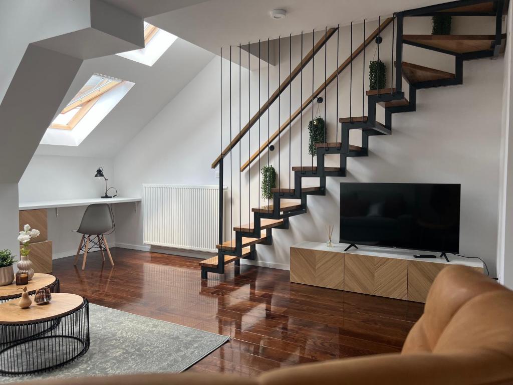 een woonkamer met een televisie en een trap bij Cozy Loft Apartment in Zagreb Center in Zagreb