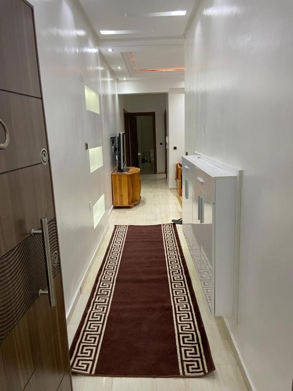 um corredor com um tapete no chão de um edifício em Appartement avec suite parentale em Mohammedia