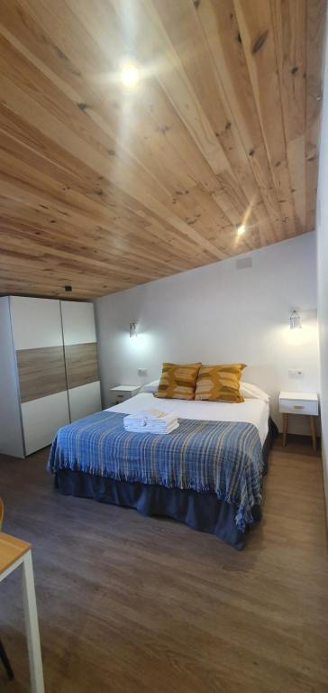 カベズエラデルバレにあるHotel Judería Valle del Jerteの木製の天井のベッドルーム1室(ベッド1台付)