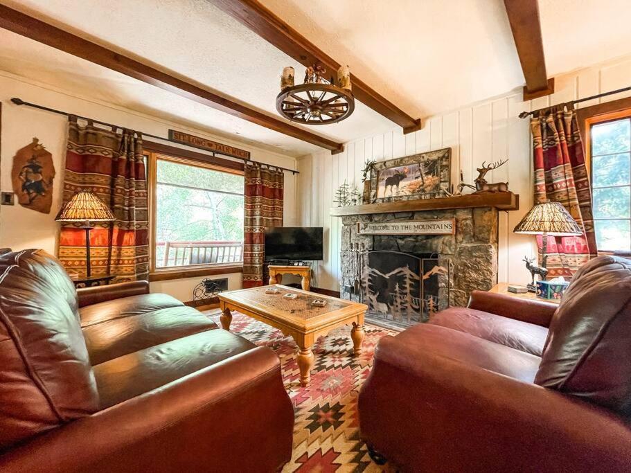 a living room with leather furniture and a fireplace at Mountainside Cabin / peaceful / near hiking trails in Cascade-Chipita Park