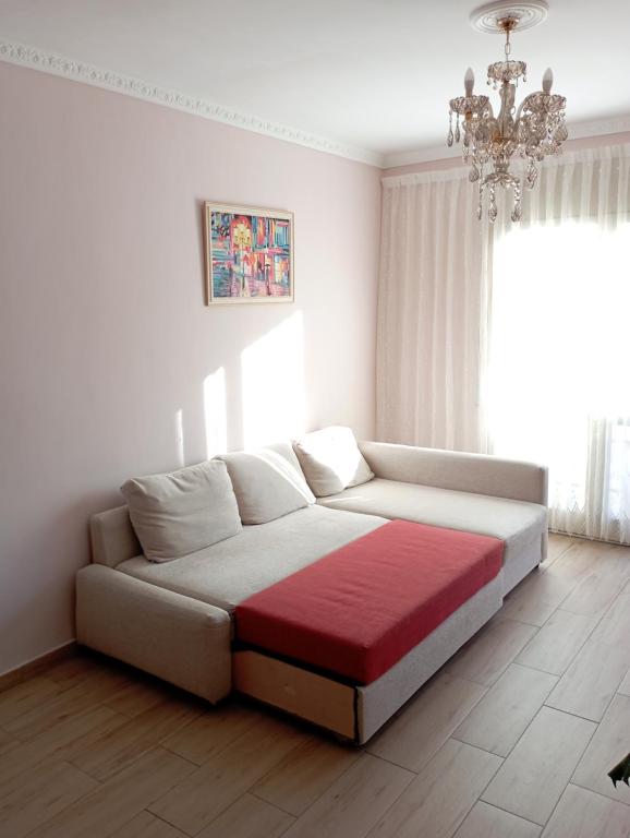 カンブリルスにあるApartamento de 3 dormitoriosのシャンデリア付きの白い部屋のベッド1台