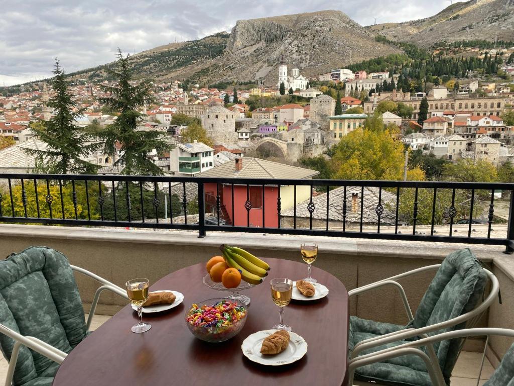 una mesa con comida y copas de vino en el balcón en Heart of Old Town Apartment, en Mostar