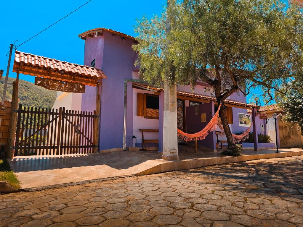 a house with a hammock in front of it at Canto do Rio Pousada in Vargem Bonita