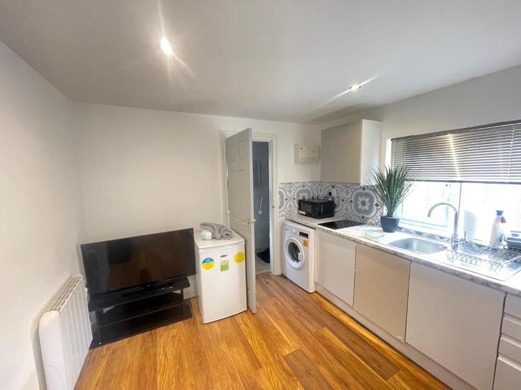 a kitchen with a sink and a washing machine at One Bedroom Annex with Private Entrance in Morden