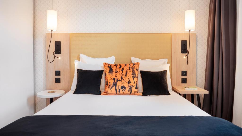 una camera da letto con un grande letto con due cuscini di Séjours & Affaires Serris Rive Gauche a Serris