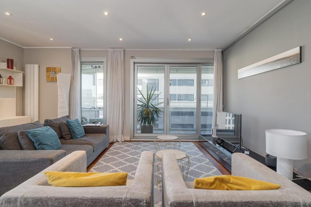 GuestReady - Apartamento com vista para o mar e terraço في برشلونة: غرفة معيشة مع أريكة وتلفزيون