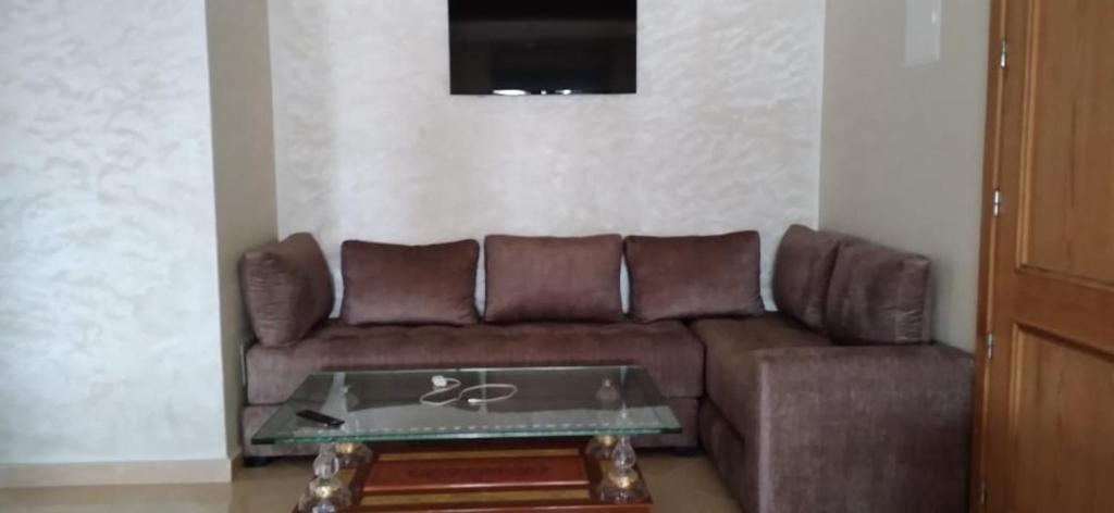 sala de estar con sofá marrón y mesa en Résidence HAMZA en Douar Ourlali