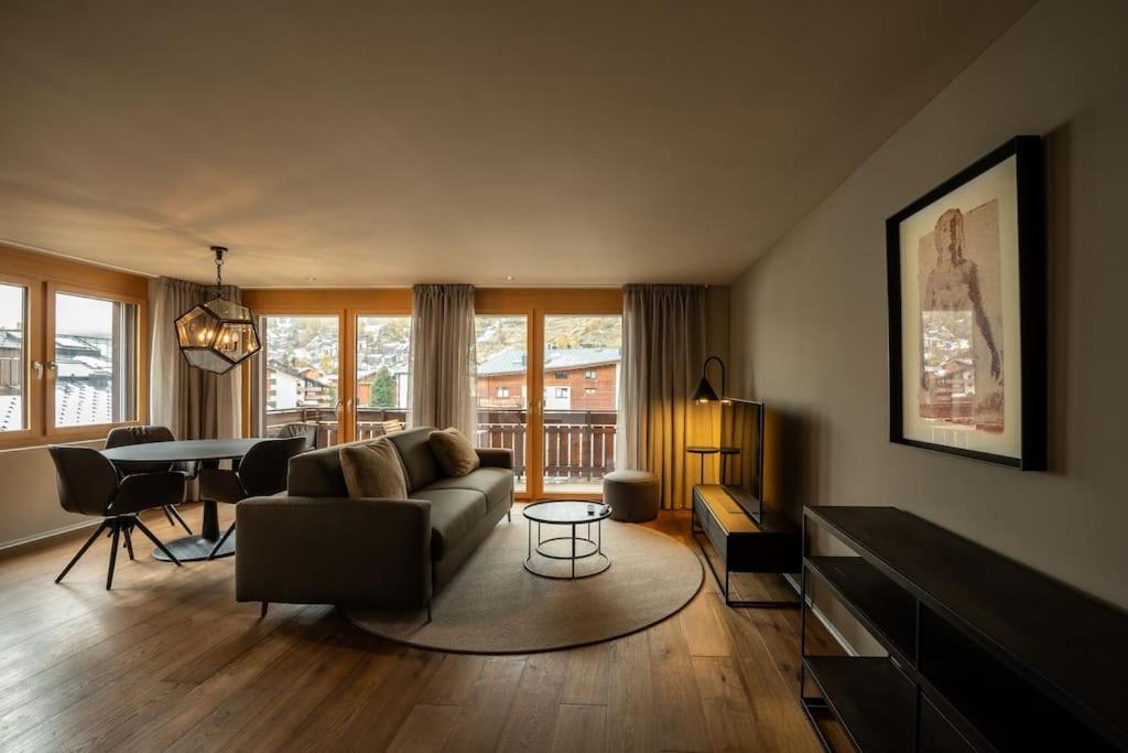 uma sala de estar com um sofá e uma mesa em Mera Peak Prime Apartment em Zermatt