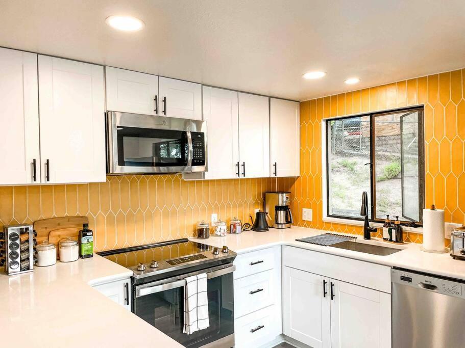 Mountain View Apartment / stylish / cozy / central في كولورادو سبرينغز: مطبخ بدولاب بيضاء ومغسلة وميكروويف