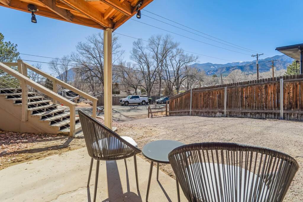 un patio con mesa, sillas y una valla en Brookside Mountain Modern Apartment / MTN views!, en Colorado Springs