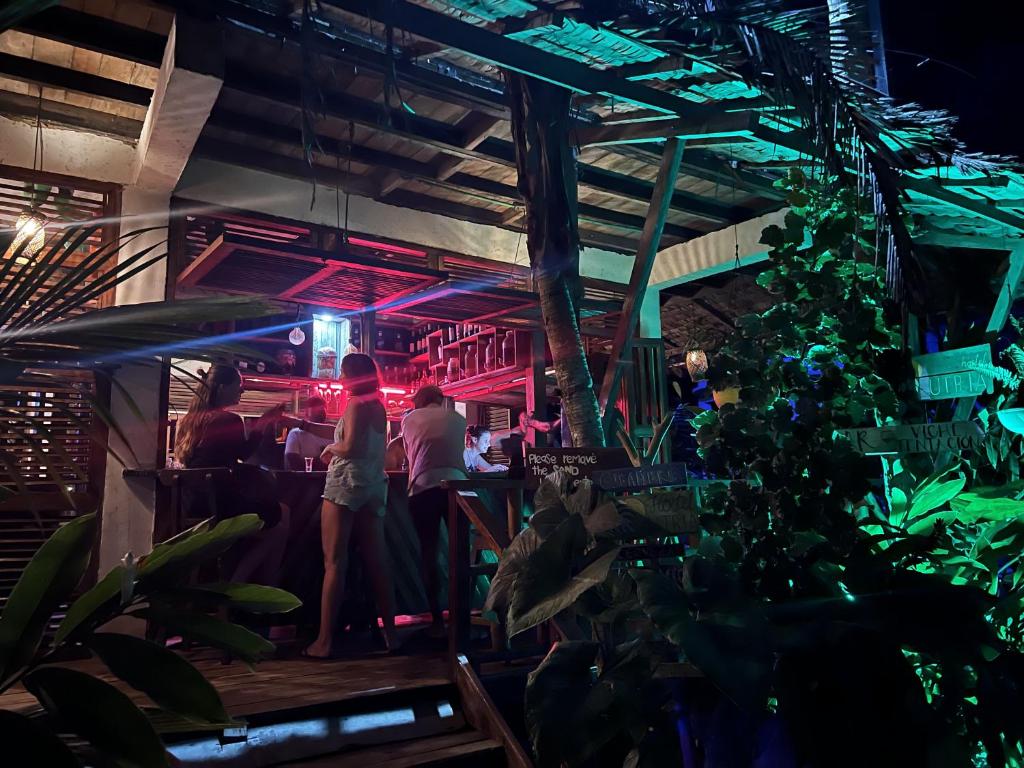 a group of people standing at a bar at night at Utria hostel in El Valle