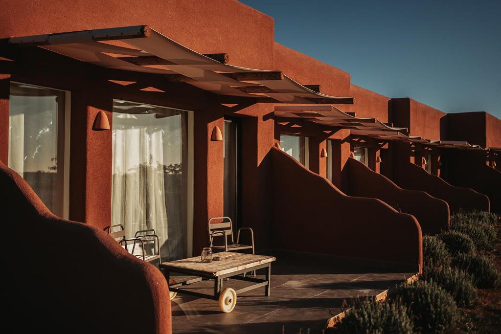 a table and chairs sitting on the side of a building at La Cobija Apartamentos - Solo Adultos in Ciudad Real