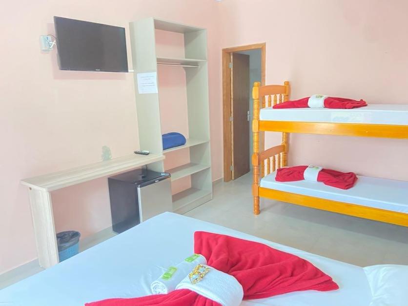 a room with two bunk beds and a tv at Pousada Villa Sambaqui in Penha