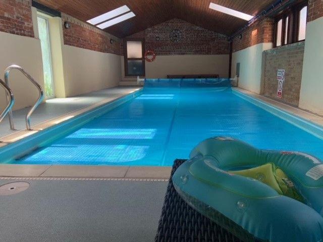 a large swimming pool with a large blue pool at The Stables in Tunstead
