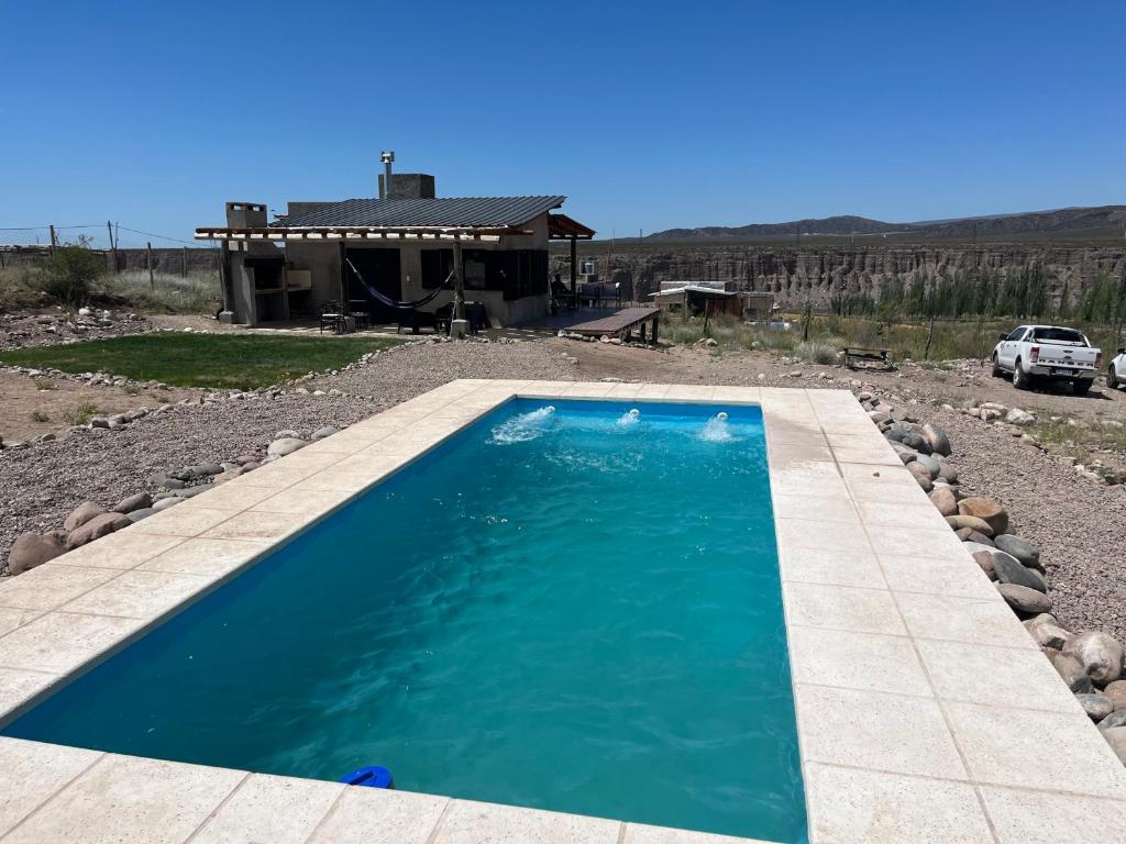 a swimming pool in front of a house at Wabi sabi, casita de montaña con pileta in Mendoza