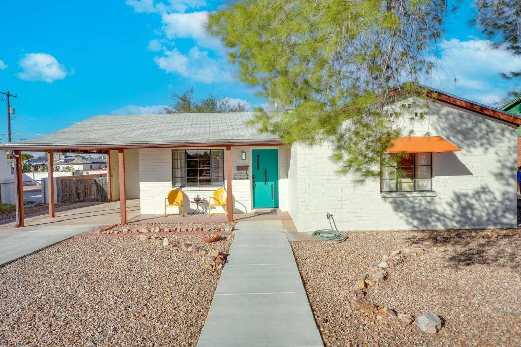 ein kleines weißes Haus mit blauer Tür in der Unterkunft Centrally Located Tucson Home with Fenced-In Yard! in Tucson