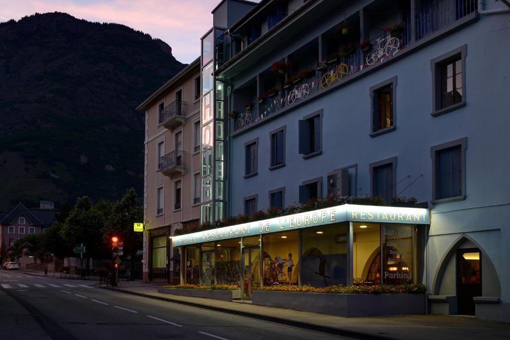 a building on the side of a street with a store at Hôtel de l'Europe in Saint-Jean-de-Maurienne