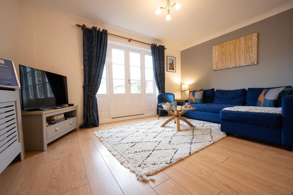 a living room with a blue couch and a tv at The Marlowe - Beautiful house in the heart of Canterbury with Free Parking in Canterbury