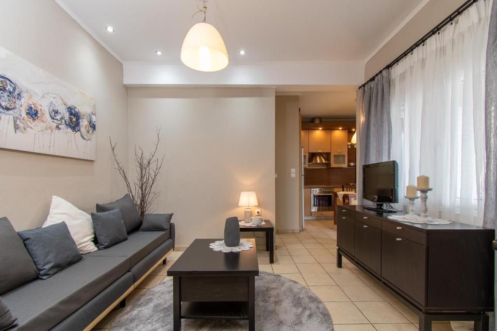 a living room with a couch and a tv at Cristina Apartment 2 in Neos Marmaras