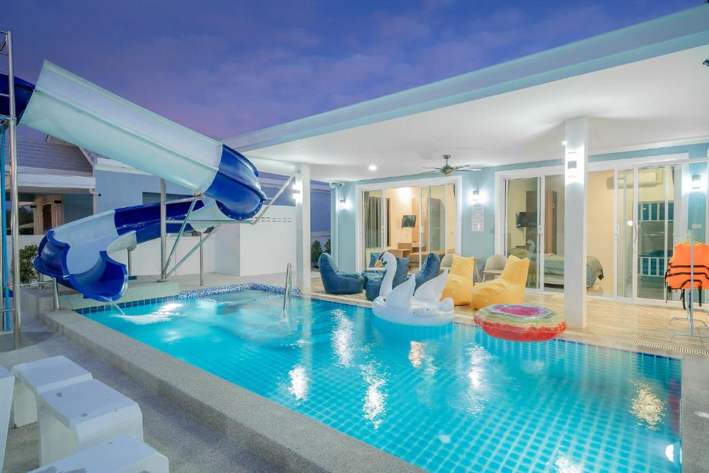 a pool with a slide in a house at พลอยพูลวิลล่า ชะอำ 1 Ploy Poolvilla Cha-am 1 in Cha Am