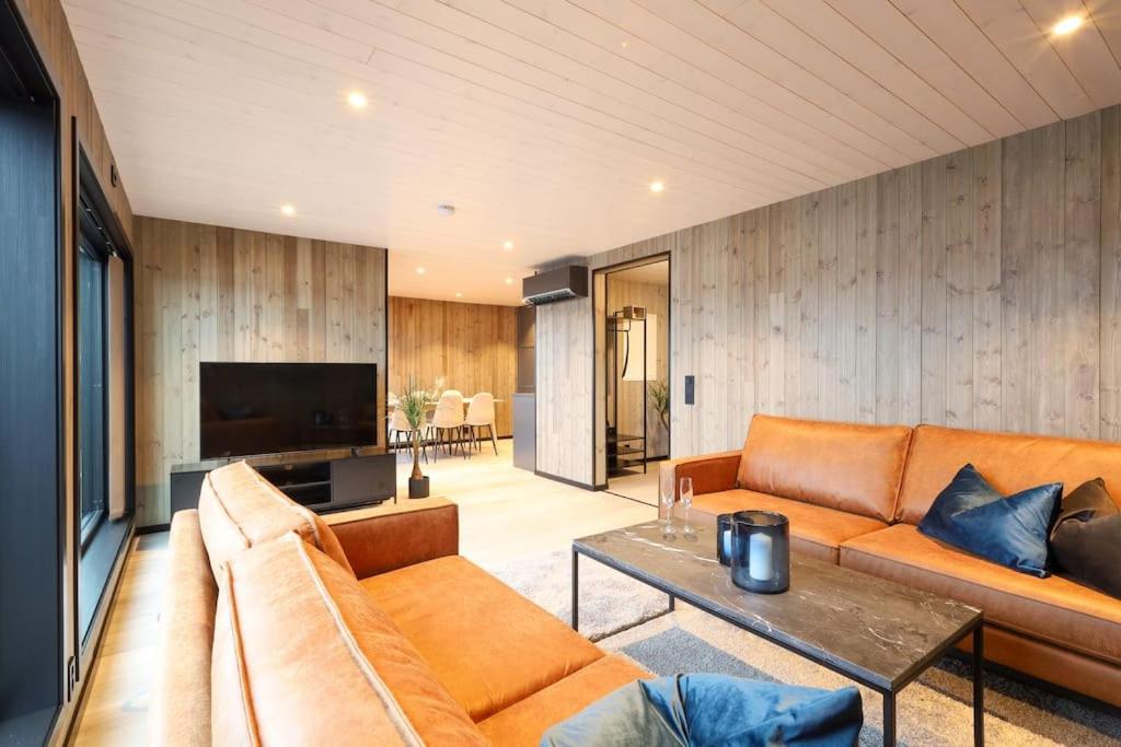 un soggiorno con divano e tavolo di Luksus panorama hytte -H25 a Mestervik