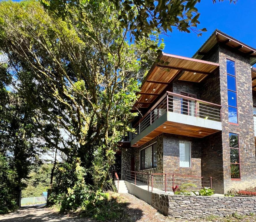 ein Backsteinhaus mit Holzdach in der Unterkunft Cougar Monteverde in Monteverde Costa Rica