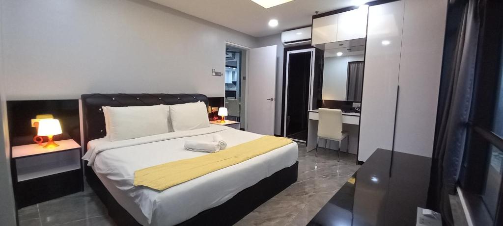a bedroom with a bed with a yellow blanket on it at RESORT SUITES AT BARJAYA TIMES SQUARE kL in Kuala Lumpur