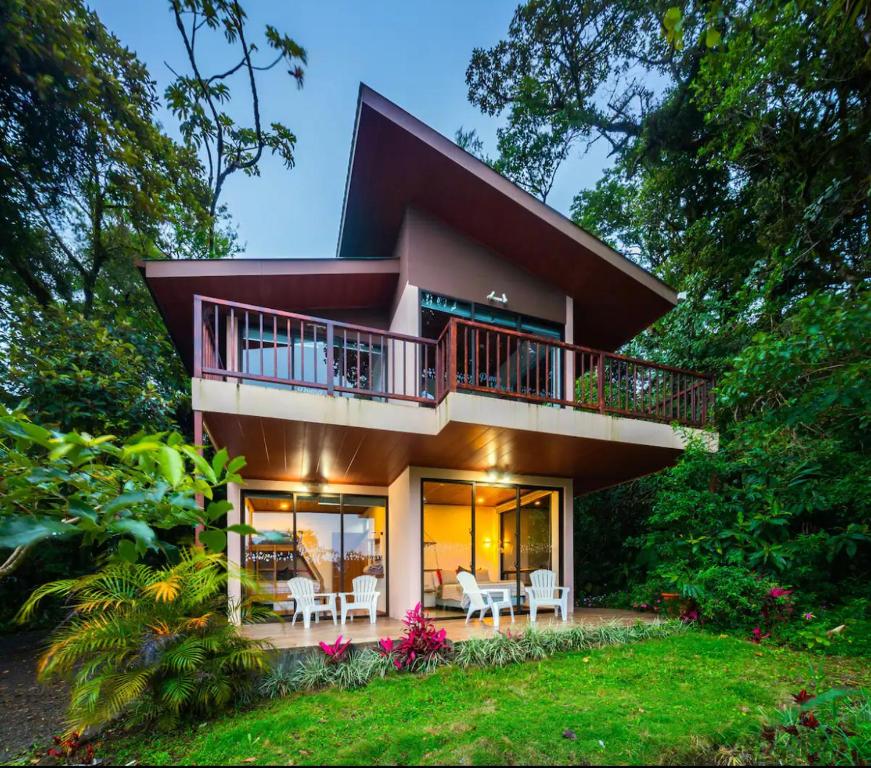 Una casa con un porche envolvente y un balcón en Puma Meraki Mountain View Monteverde en Monteverde