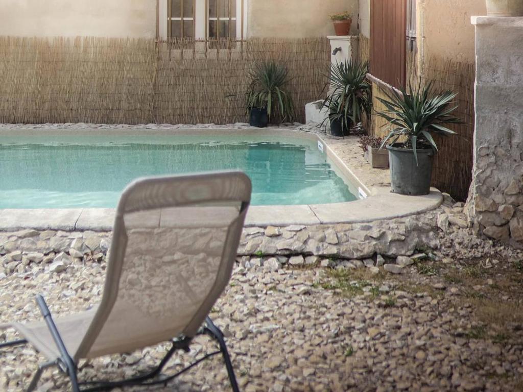 uma cadeira sentada em frente a uma piscina em Maison Plan-d'Orgon, 4 pièces, 7 personnes - FR-1-767-4 em Plan-dʼOrgon