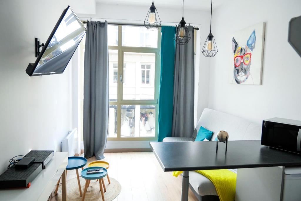 - un salon avec une table et une fenêtre dans l'établissement Grand studio hyper centre de Saint Quentin, à Saint-Quentin