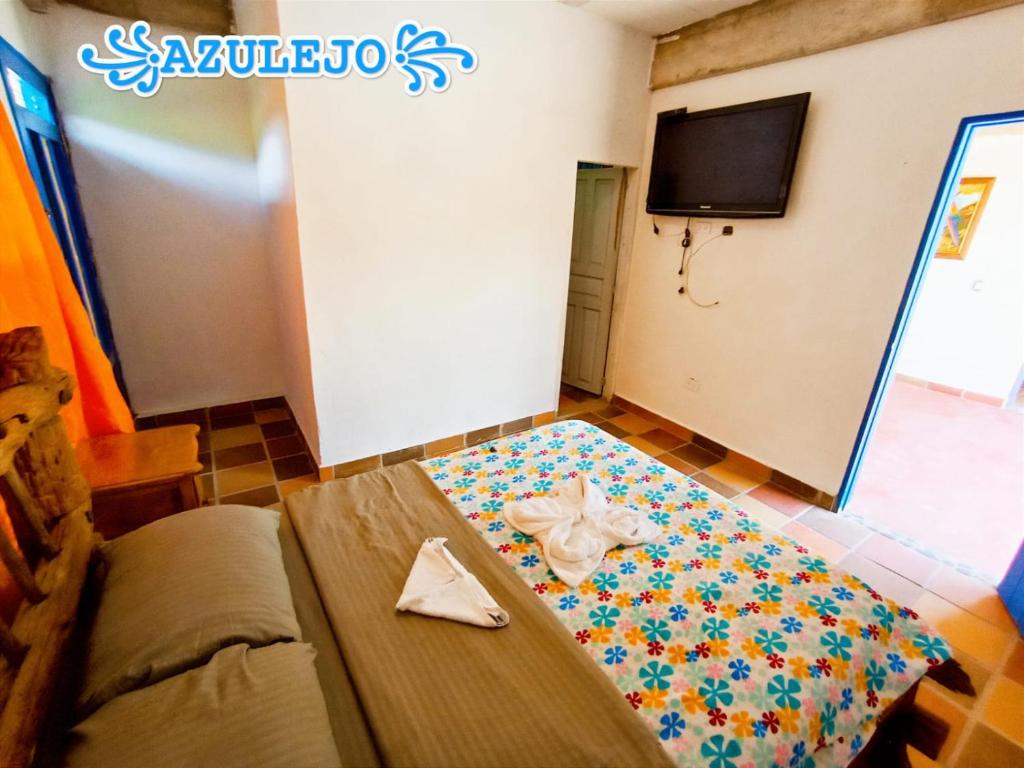 ein Zimmer mit einem Bett mit einer Serviette darauf in der Unterkunft AZULEJO in Jericó