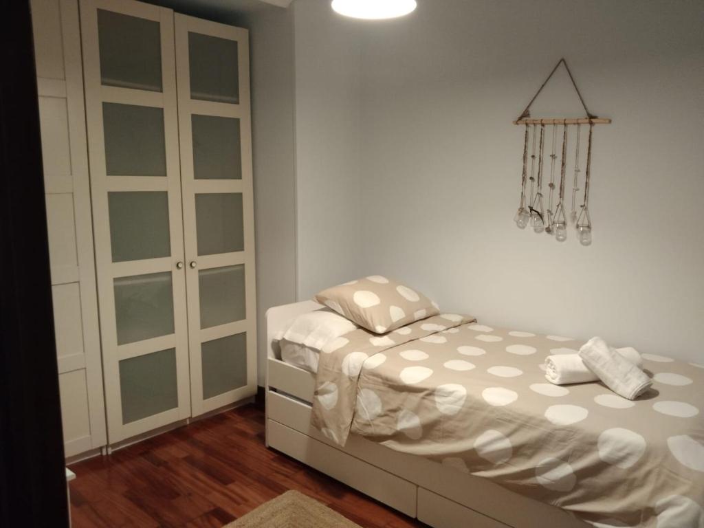 ein kleines Schlafzimmer mit einem Bett und einem Schrank in der Unterkunft Apartamento Etxe Morea, Casco Histórico in Bermeo