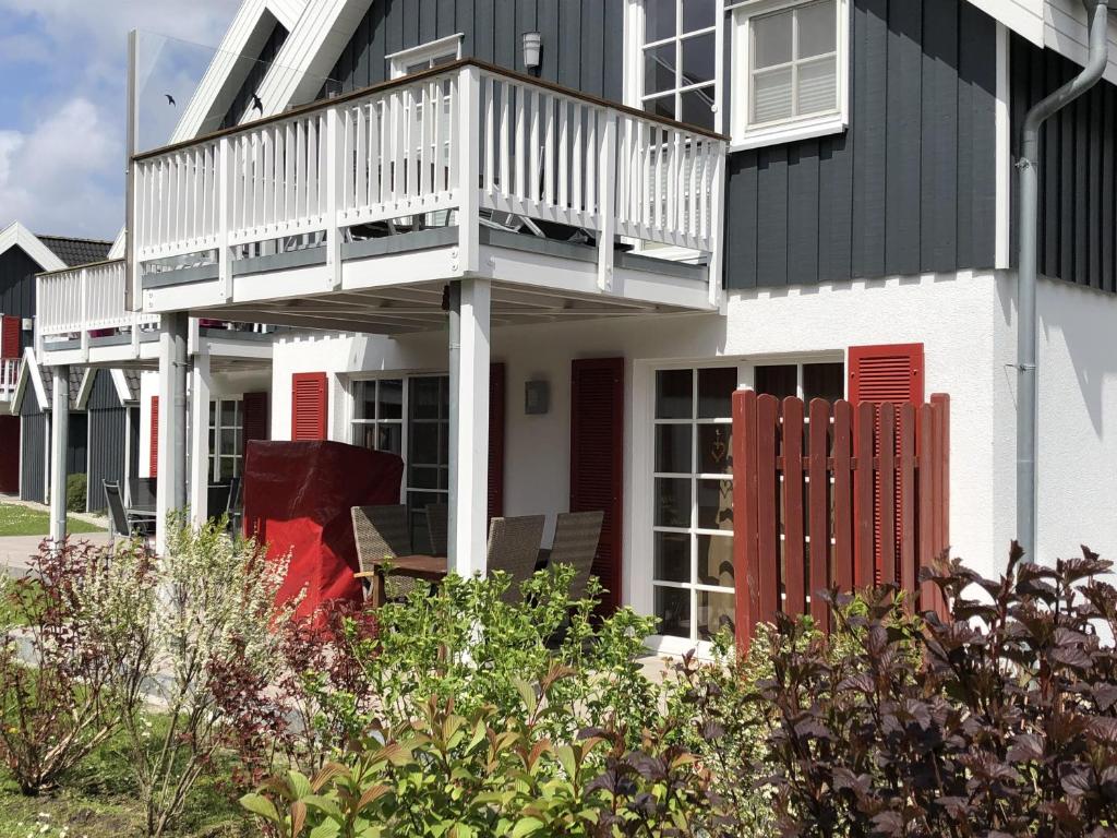 a house with a deck and a balcony at Ferienwohnung Kajüte 19 in Greetsiel