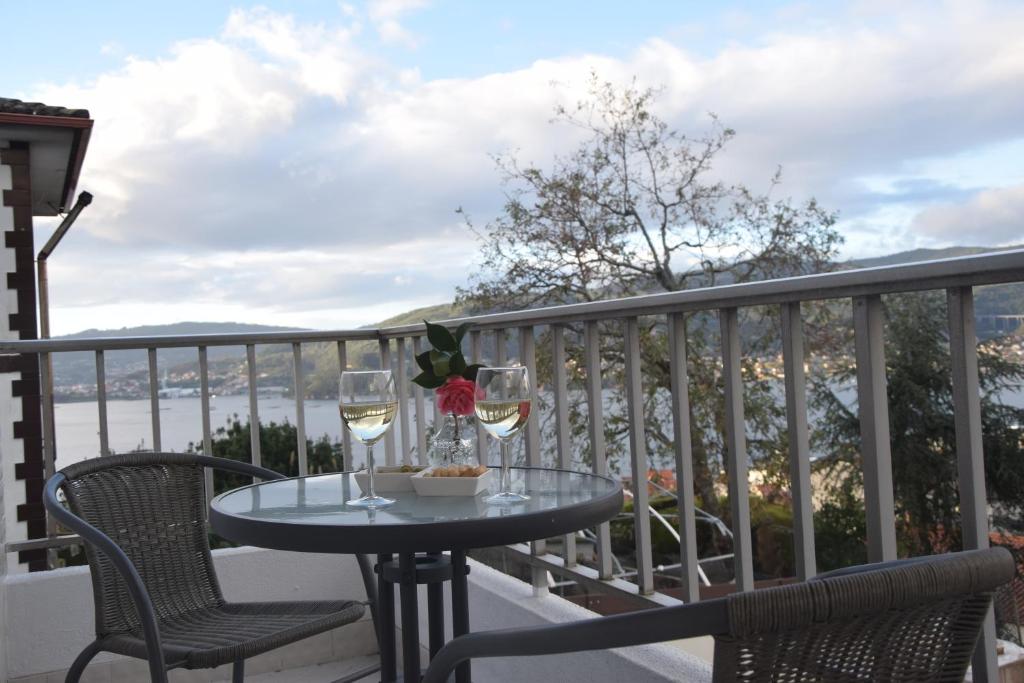 einen Tisch mit zwei Gläsern Wein auf dem Balkon in der Unterkunft Casa en Chapela, al lado de Vigo y con vistas a la Ría in Redondela