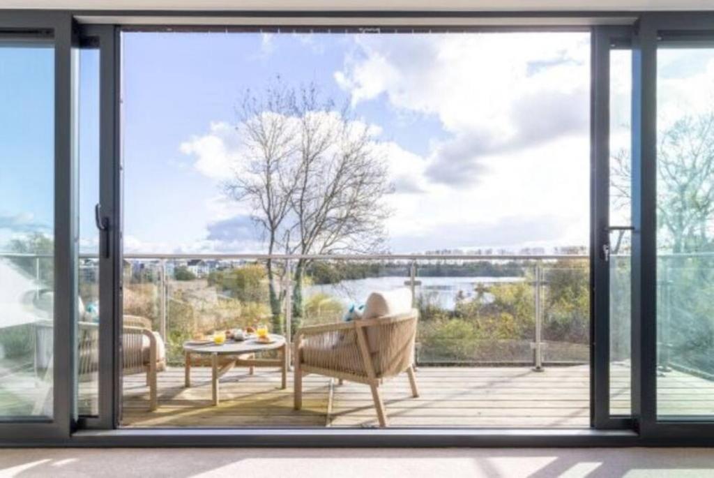 een kamer met een groot raam met uitzicht op het water bij The Lookout LR11 Lakeside Spa Holidays in Somerford Keynes
