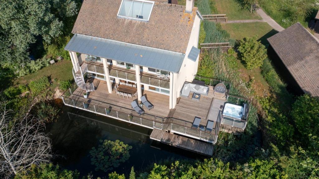 an aerial view of a large house on the water at Garden Villa CW70 HOT TUB Lakeside Spa in Somerford Keynes