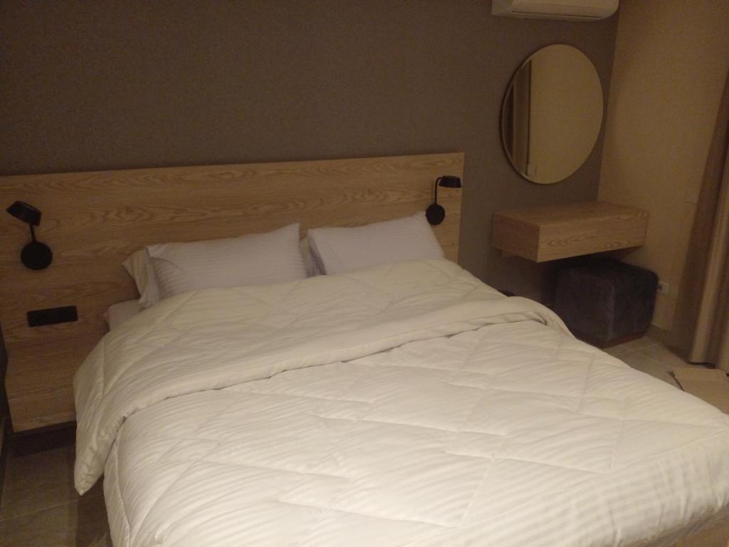 uma cama com lençóis brancos e almofadas num quarto em Sun gate house no Cairo