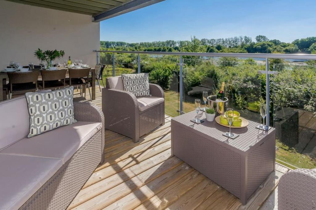 a patio with a table and chairs on a deck at Sundowner HM108 Lakeside Spa Property in Somerford Keynes