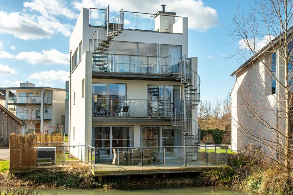 an apartment building with a spiral staircase on it at Reflections HM77 HOT TUB Lakeside Spa NEW in Somerford Keynes